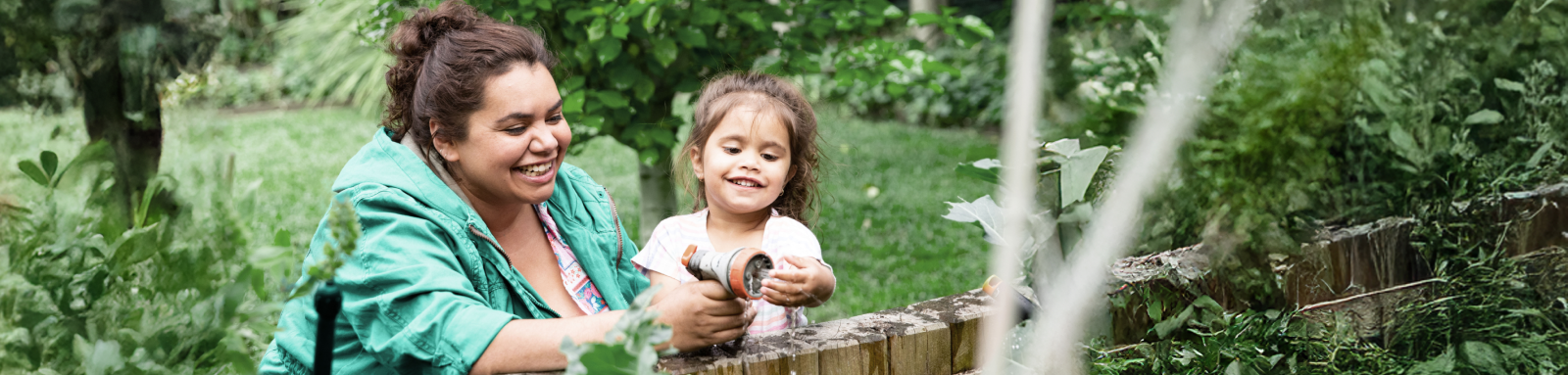 woman and child watering a garden